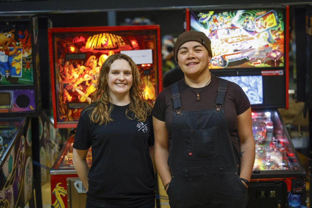 Crystal and Jackie in front of pinball tables
