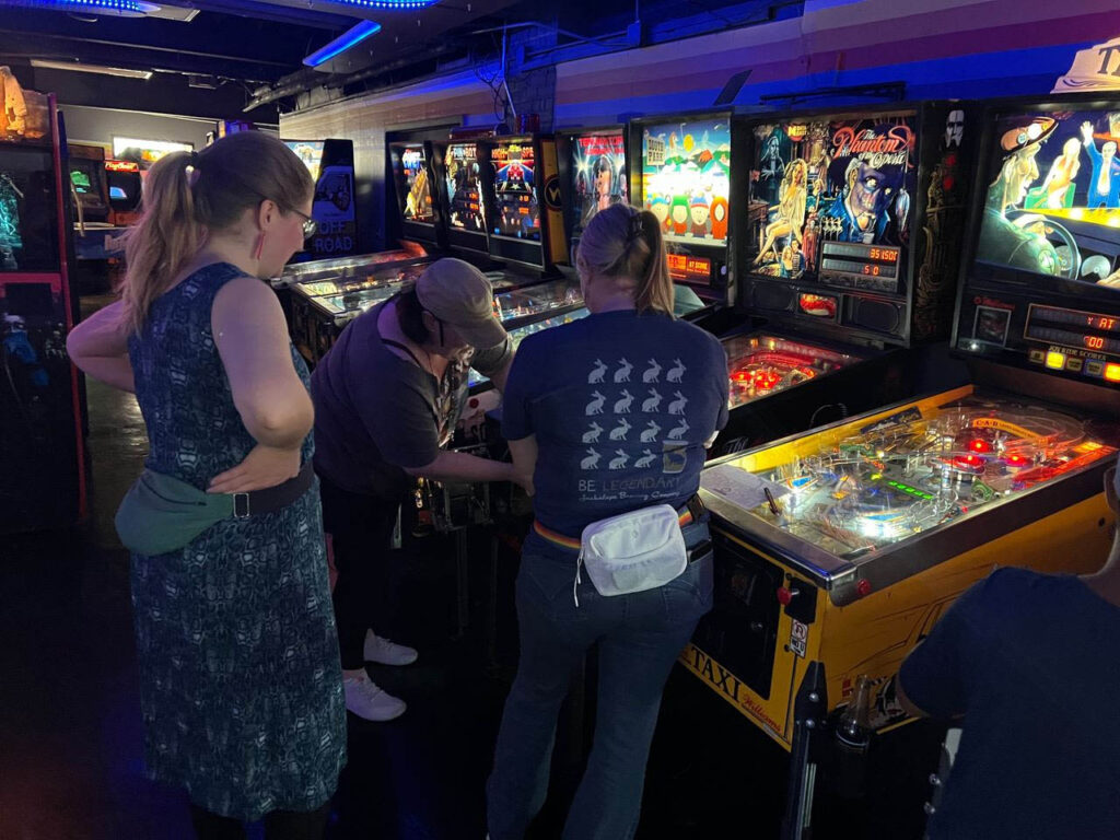 Players coining up to play Phantom of the Opera pinball