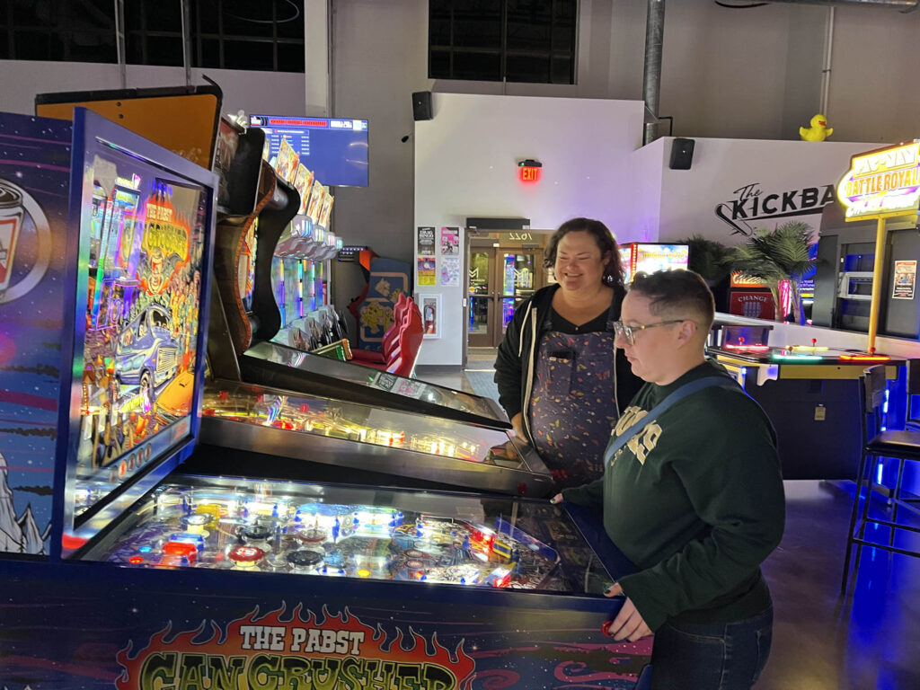 Players enjoying pinball at Kickback
