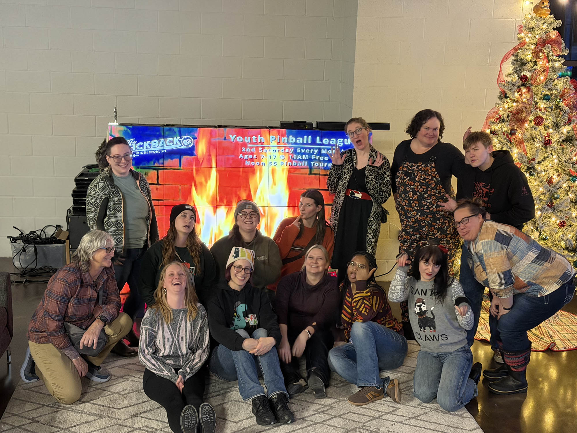 The group in front of the tv fireplace and christmas tree for the december Belles Event.
