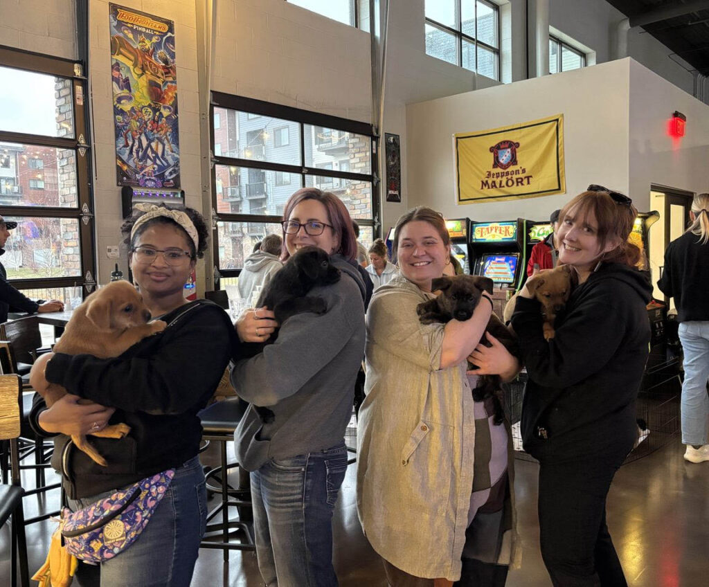 Top four players holding puppies