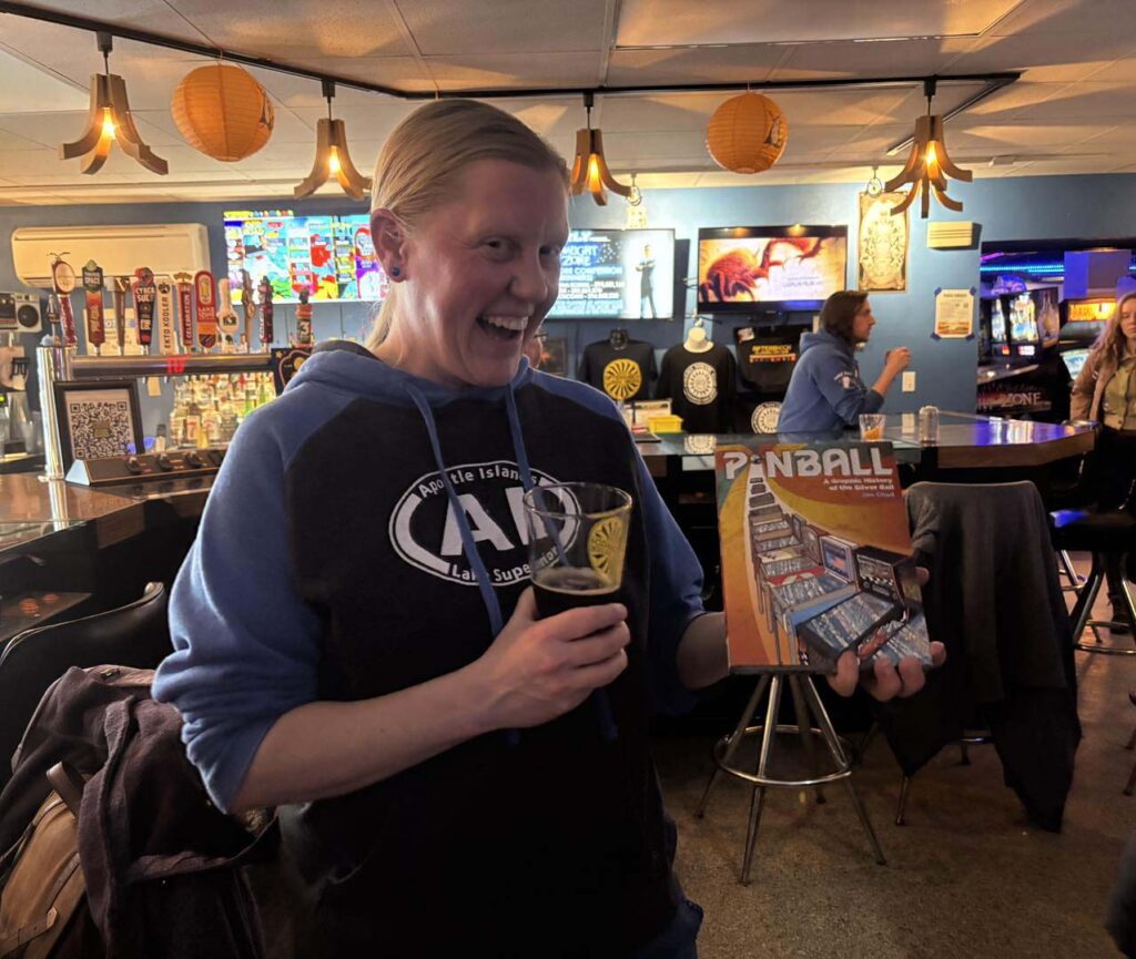 Belles holding a pinball magazine